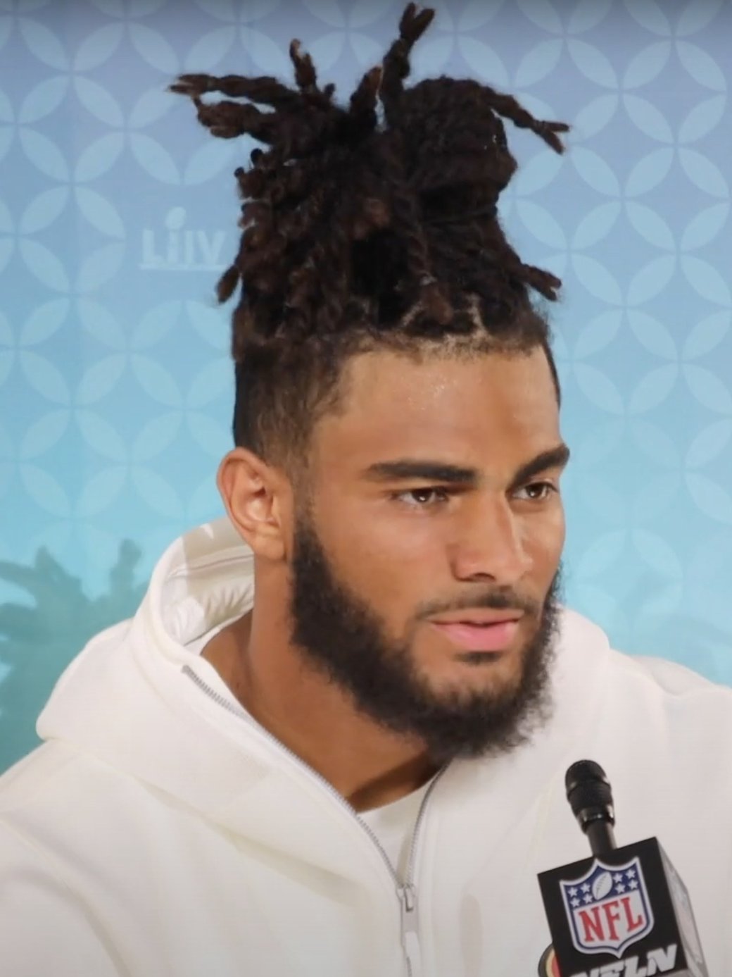 Fred Warner at a press availability in a white hooded sweatshirt