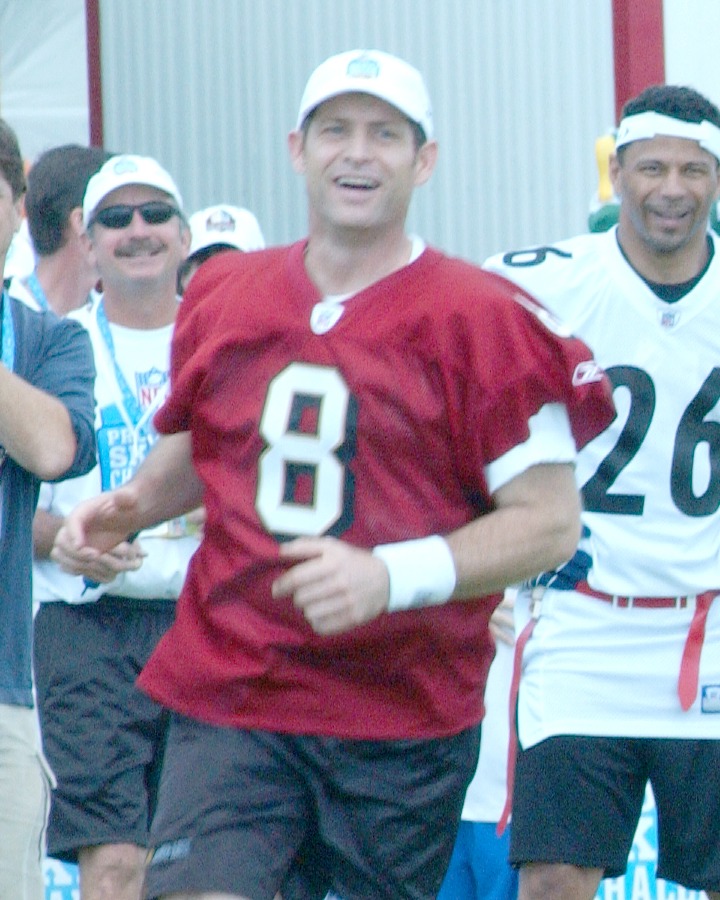 Steve Young smiling in a red San Francisco 49ers number 8 jersey at the 2006 Pro Bowl Skills Challenge in Hawaii
