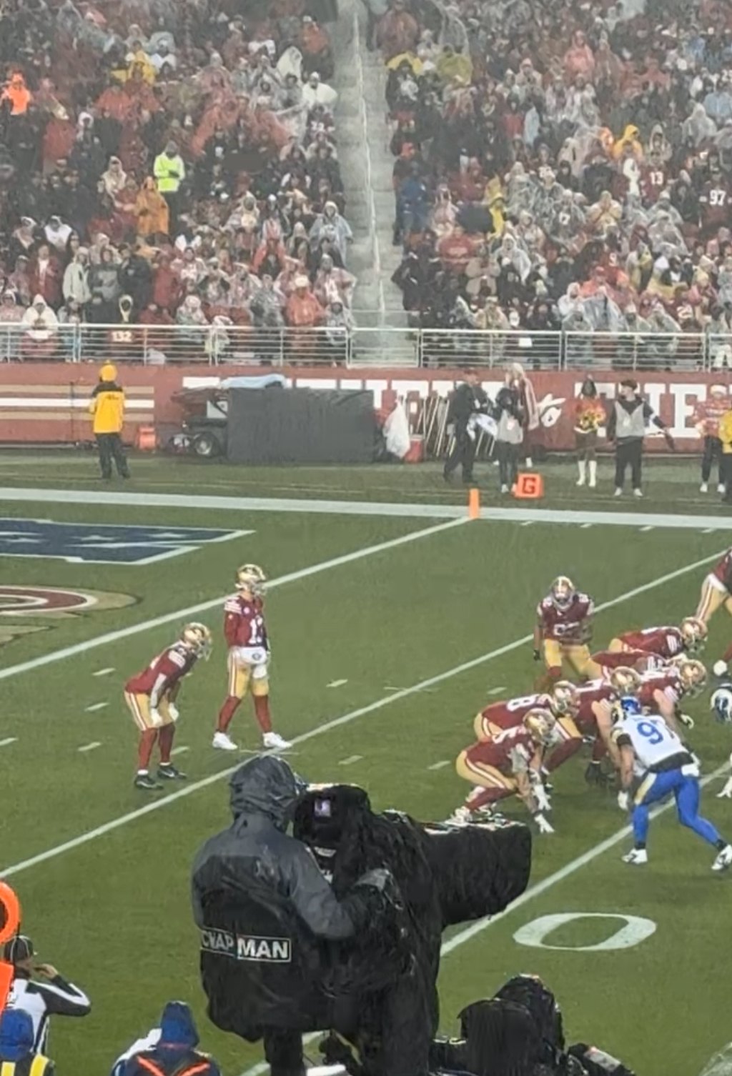 The 49ers offense lined up against the Rams at Levi's Stadium on a rainy night, seen from the stands