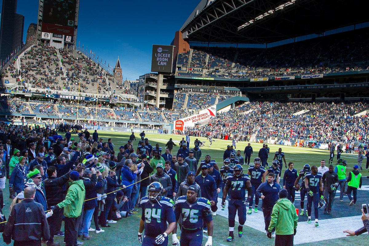 Seahawks players walking onto the field through a crowd of fans before hosting the 49ers in Seattle